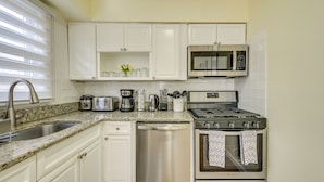 A modern kitchen with white cabinets, stainless steel appliances, a microwave, toaster, and a dishwasher. - Walk to Park & Public Transit: Jersey City Apt (Jersey City)