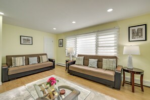 Ein Wohnzimmer mit zwei Sofas, einem Couchtisch und einer Lampe.