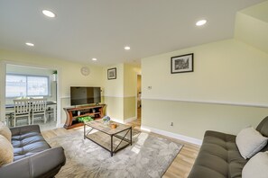 A living room with a sofa, coffee table, and TV. - 6 Mi to Lower Manhattan: Apt w/ Shared Patio! (Jersey City)