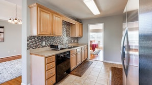 A modern kitchen with wooden cabinets, a tiled backsplash, and a stainless steel refrigerator. - 6 Mi to Downtown Birmingham! Family Home (Birmingham)