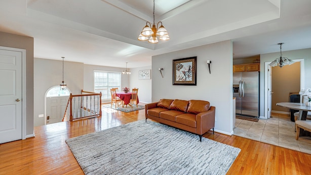 A spacious living area with hardwood floors, a gray rug, a brown leather sofa, and a dining area with a red tablecloth. - 6 Mi to Downtown Birmingham! Family Home (Birmingham)