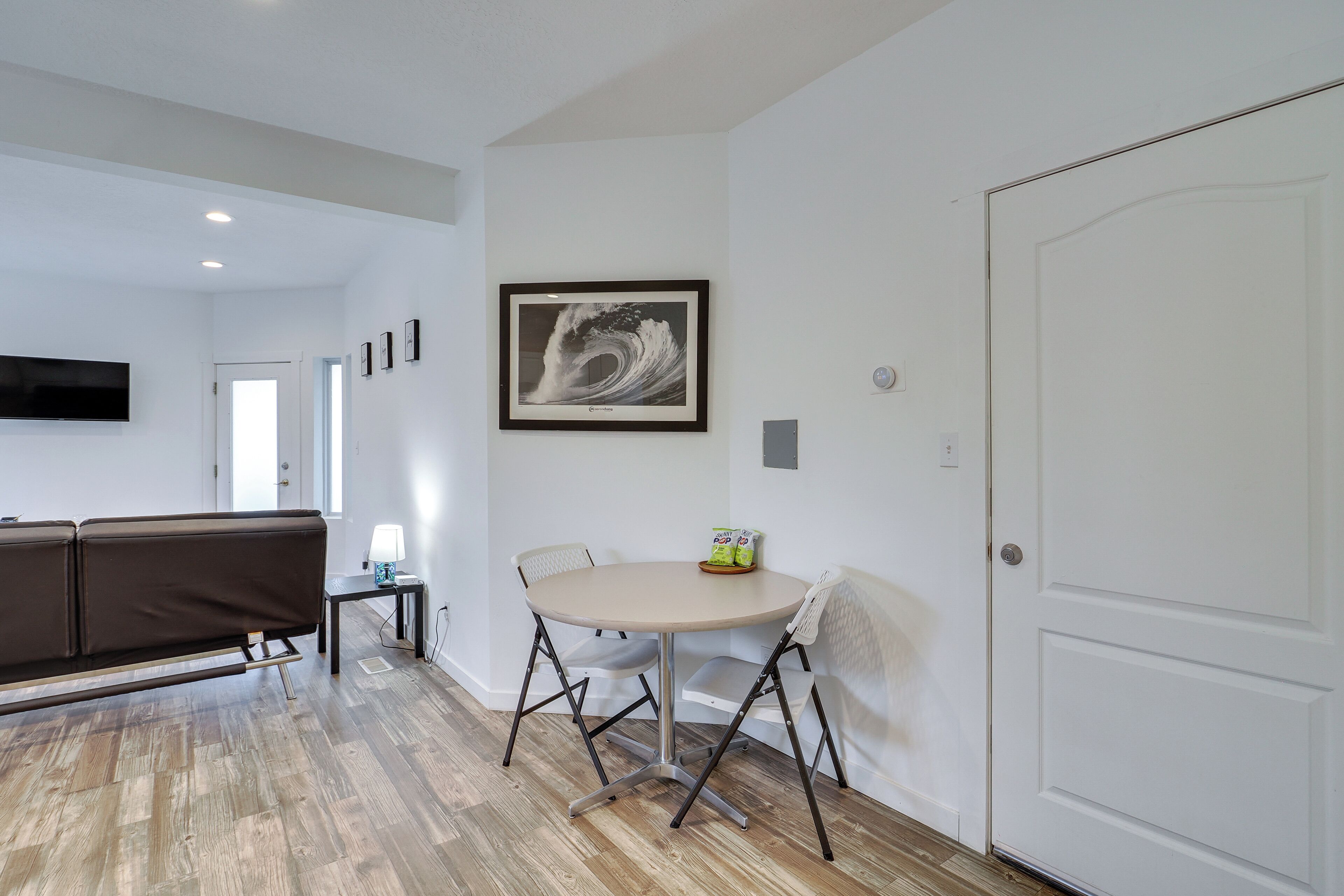 A modern living room with a sofa, a round table, and a framed artwork on the wall.