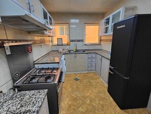 Private kitchen - Delightful 3-Bedroom Family Apartment with Garden View opposite to Safiya Garden (Sharjah)