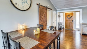 A dining area with a wooden table, chairs, and a map on the wall. - Private Dock at Ozarks Home Next to Margaritaville (Osage Beach)