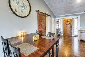 A dining area with a wooden table, chairs, and a map on the wall. - Private Dock at Ozarks Home Next to Margaritaville (Osage Beach)