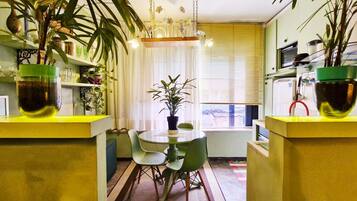 Una cocina compacta con una mesa de comedor y sillas, rodeada de plantas en macetas.