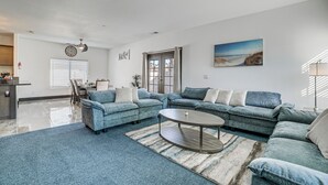 A spacious living room with a sectional sofa, a coffee table, and a dining area with a table and chairs. - Fully Updated! Prime Riverside Spot Near Dtwn (Riverside)
