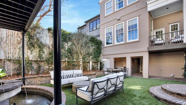 A backyard with a small pond, a white outdoor sofa, and a brick patio. - Hidden Garden Retreat in the Heart of Downtown Savannah (savannah)