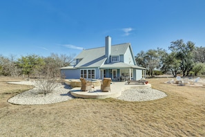 A house with a covered patio, outdoor seating, and a fire pit. - Hill Country Escape: Family Home w/ Outdoor Oasis (Dripping Springs)