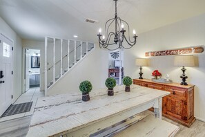 A kitchen with a rustic wooden island, a chandelier, and a farmhouse sign on the wall. - Hill Country Escape: Family Home w/ Outdoor Oasis (Dripping Springs)