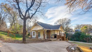 A single-story house with a front porch, a stone pillar, and a garage. - Walk to Avondale Eats & Brews: Urban Getaway (Birmingham)