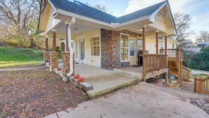 A two-story house with a covered porch, brick columns, and a wooden staircase. - Walk to Avondale Eats & Brews: Urban Getaway (Birmingham)