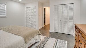 A bedroom with a bed, a dresser, and two closets. - Deck + Pool Table! Walk to Dtwn Jensen Beach (Jensen Beach)