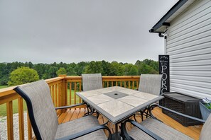 A deck with a table and chairs, overlooking a forested area. - Cozy Hillside Retreat Near Dale Hollow Lake! (Burkesville)