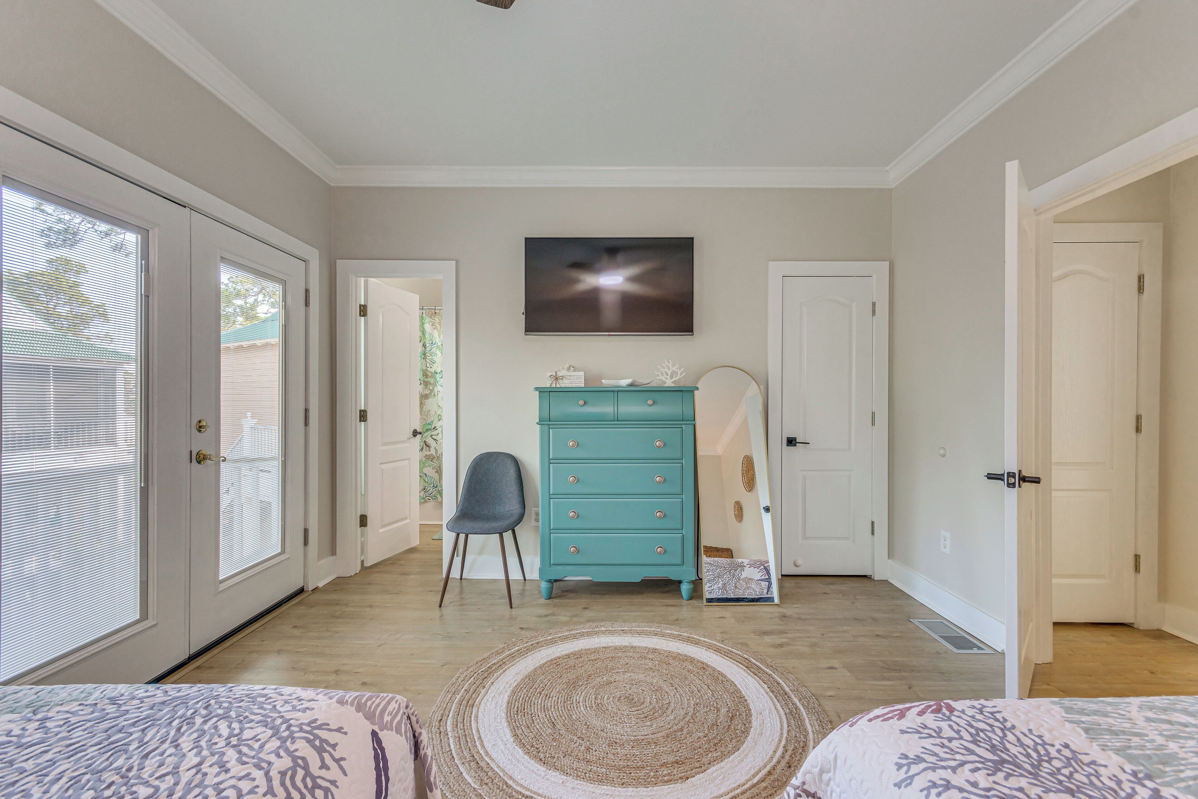 Une chambre à coucher avec un lit, une commode et un tableau accroché au mur.