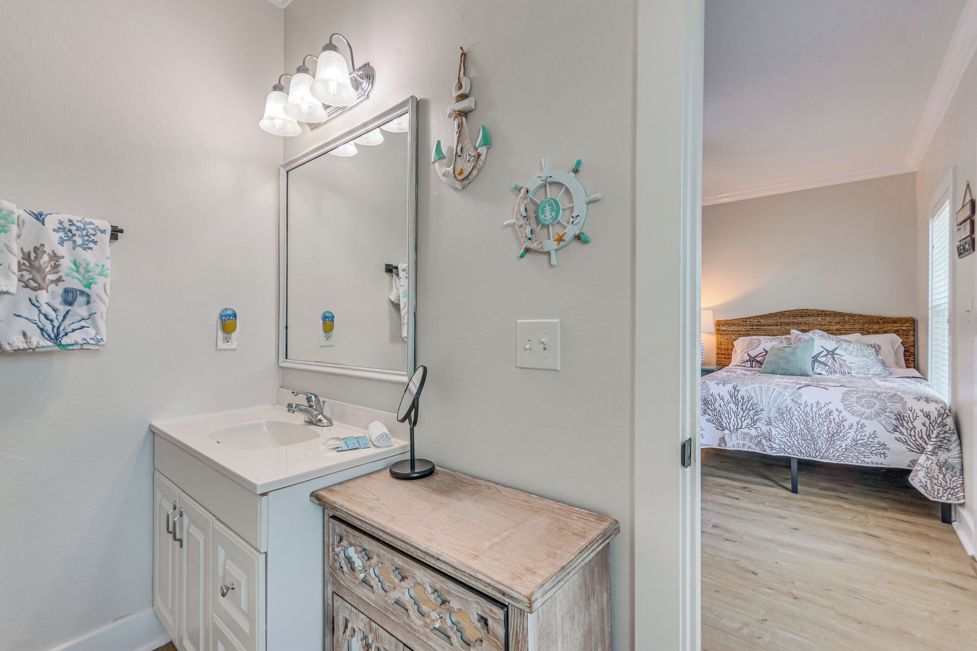 Une chambre à coucher avec un lit, une table de chevet et un miroir fixé au mur.