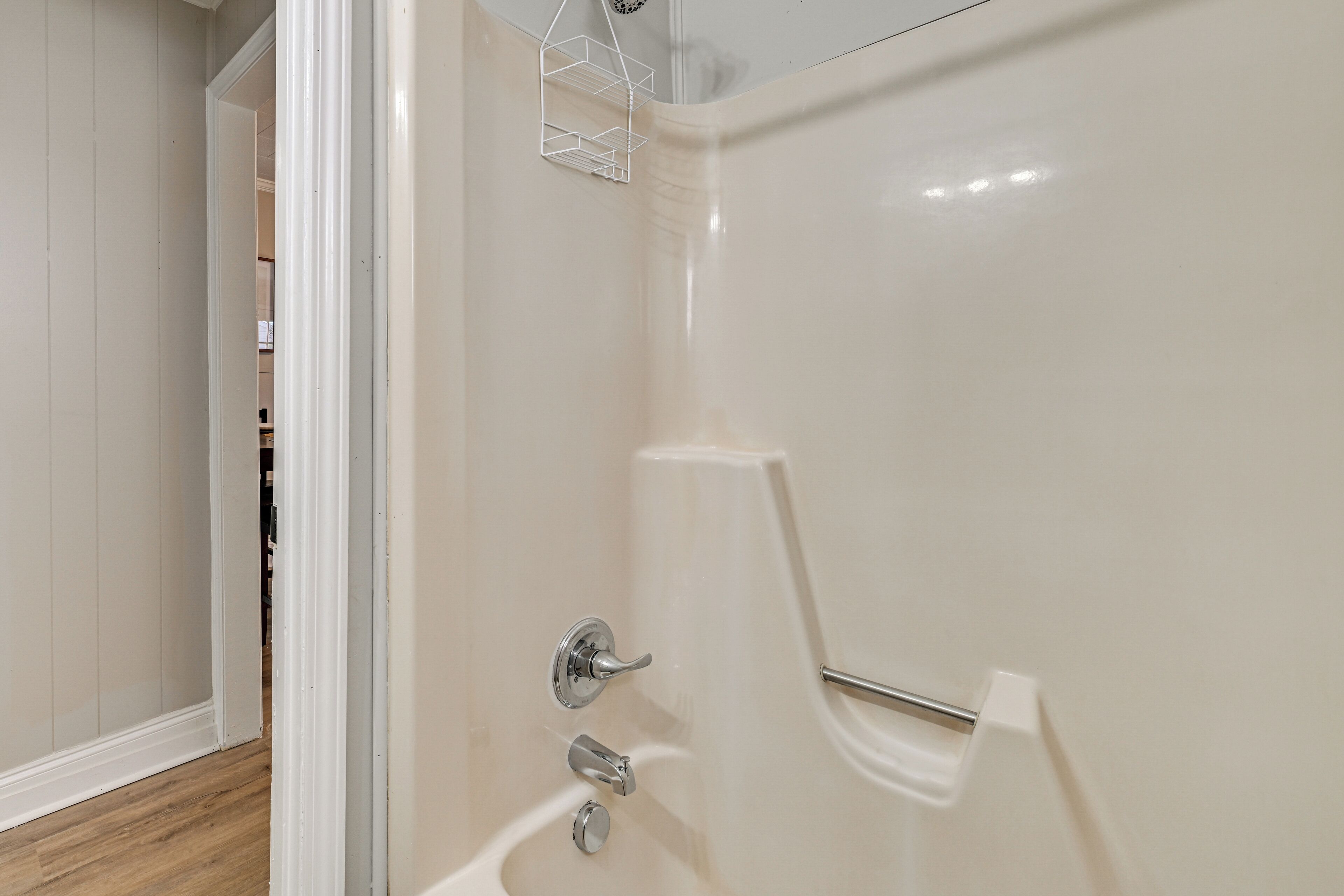 A bathroom with a white bathtub, a chrome faucet, and a towel rack.