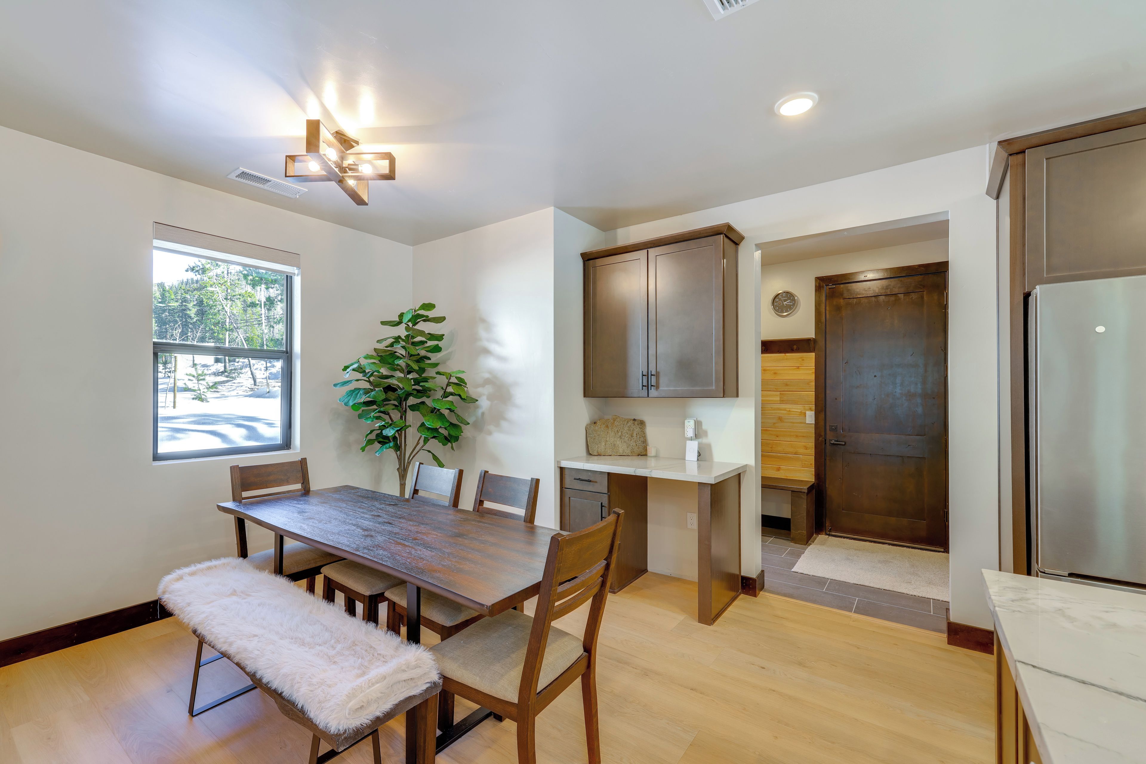 A modern kitchen with wooden cabinetry, a built-in island, and a large window providing natural light.