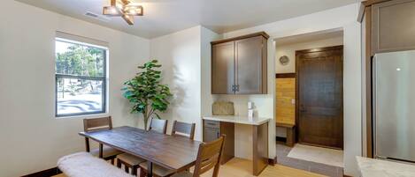 A modern kitchen with wooden cabinetry, a built-in island, and a large window providing natural light.
