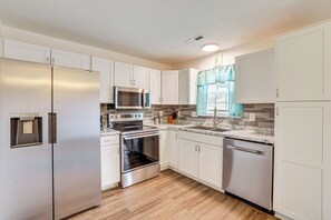A modern kitchen with white cabinets, stainless steel appliances, a microwave, oven, and dishwasher. - Family Home in Fountain Inn, 2 Mi to Main St! (Fountain Inn)