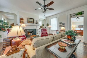 Un salon comprenant un canapé, une table basse, une cheminée et un ventilateur de plafond.