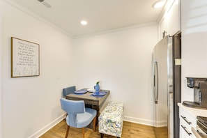 A modern kitchen with a stainless steel refrigerator, a coffee maker, and a dining table with blue placemats. - Fully Renovated! Goldsboro Gem w/ Yard & Porch (Goldsboro)