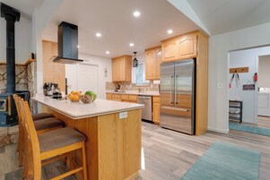 Una cocina moderna con armarios de madera, un refrigerador de acero inoxidable y una chimenea de piedra.