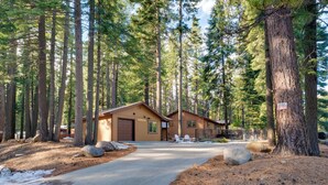A cabin with a garage, surrounded by tall pine trees and a snow-covered ground. - Gateway to Lassen Volcanic! Cozy Woodland Studio (Westwood)