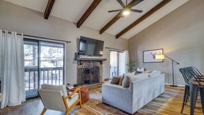 A spacious living room with a fireplace, a sofa, a TV, and a dining area.