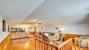 A spacious living area with a wooden floor, a dining table, and a sofa. - Cozy Barn Apt w/ 5-acre Pond in South Georgia! (Doerun)