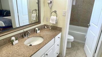 A bathroom with a sink, mirror, towel rack, and a hairdryer.