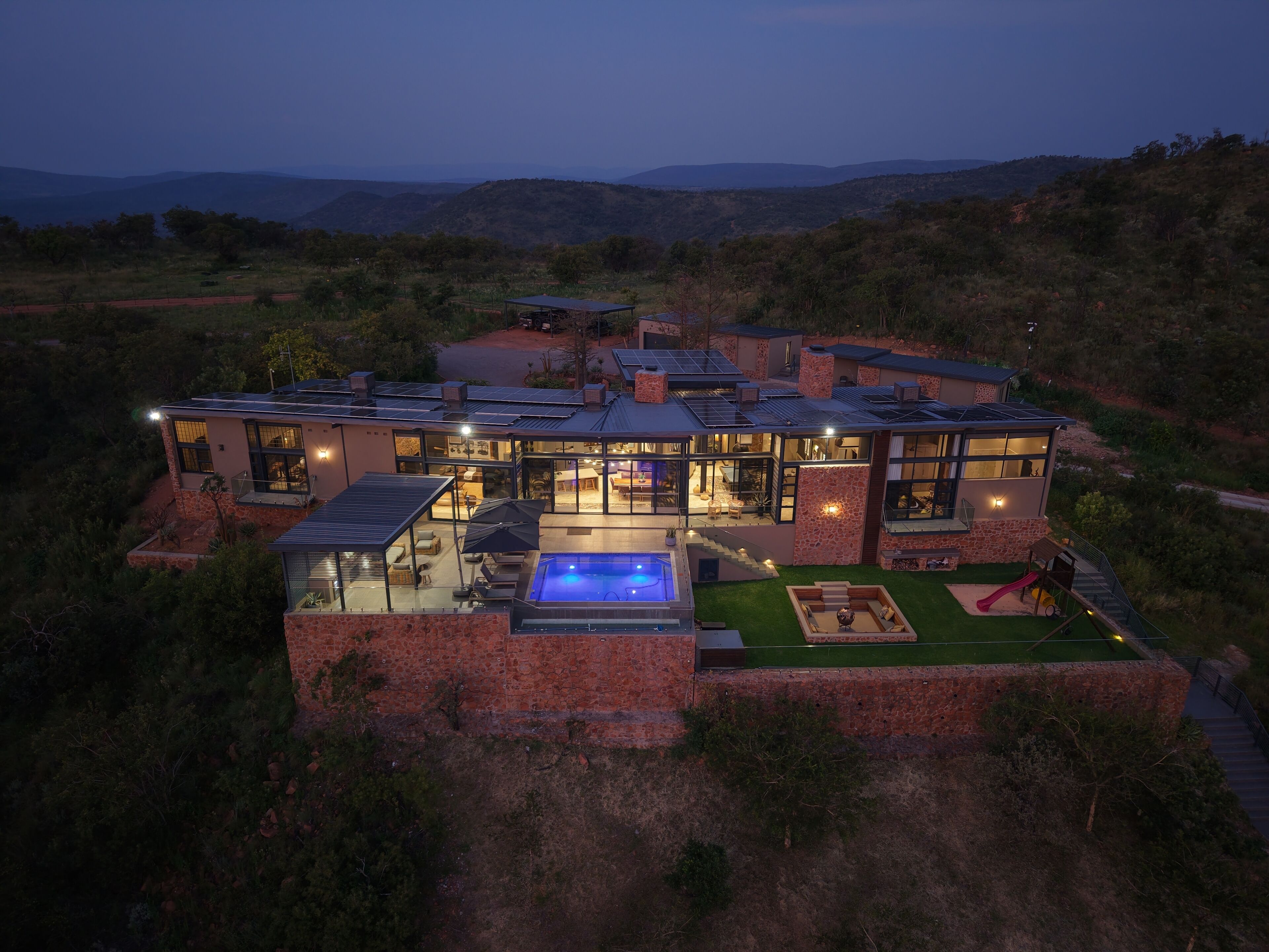 Une maison moderne dotée d’une piscine, d’un espace extérieur aménagé et offrant une vue sur le paysage environnant.