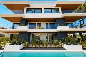 A modern multi-story building with a pool in front. - Aurora Sand 2 - Carraro immobiliare Jesolo (Lido di Jesolo)