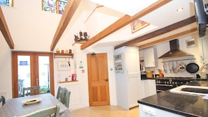A kitchen with wooden beams, a stove, and a sink. - Unique town house with games room (Padstow)