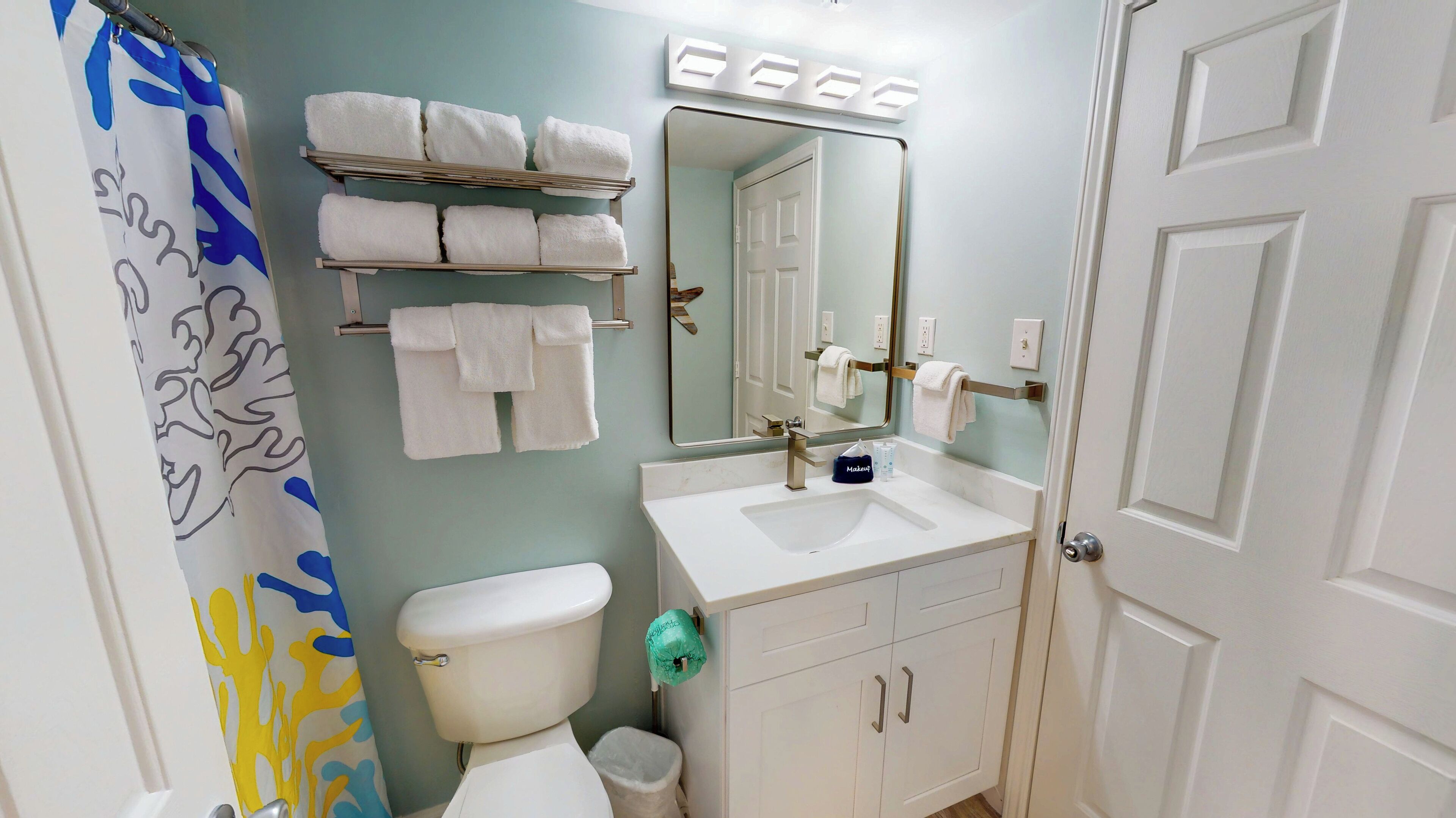 A bathroom with a toilet, sink, and towel rack.