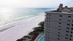A beachfront hotel with a pool, ocean view, and a high-rise building with balconies. - 2br/2ba Beachfront Condo With Stunning Ocean Views + Heated Indoor/outdoor Pool (Orange Beach)