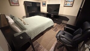 A bedroom with a bed, a desk, a chair, a TV, and a wardrobe. - Cozy & quiet 2 bedroom country getaway, close to all the fun! (Elberta)