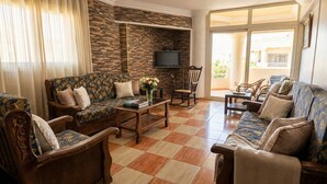 A living room with a sofa, armchairs, a coffee table, and a television. - Panoramic Sea view apartment in Alexandria (Alexandria Governorate)
