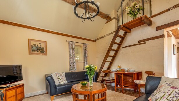 Ein gemütliches Wohnzimmer mit einer Couch, einem Couchtisch, einem Fernseher und einem Kamin.