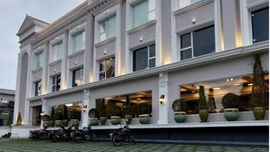 A hotel named "NILAYAT INN" with a classical architectural style, featuring large windows and a well-lit facade. - NILAYAT INN (Thrissur)