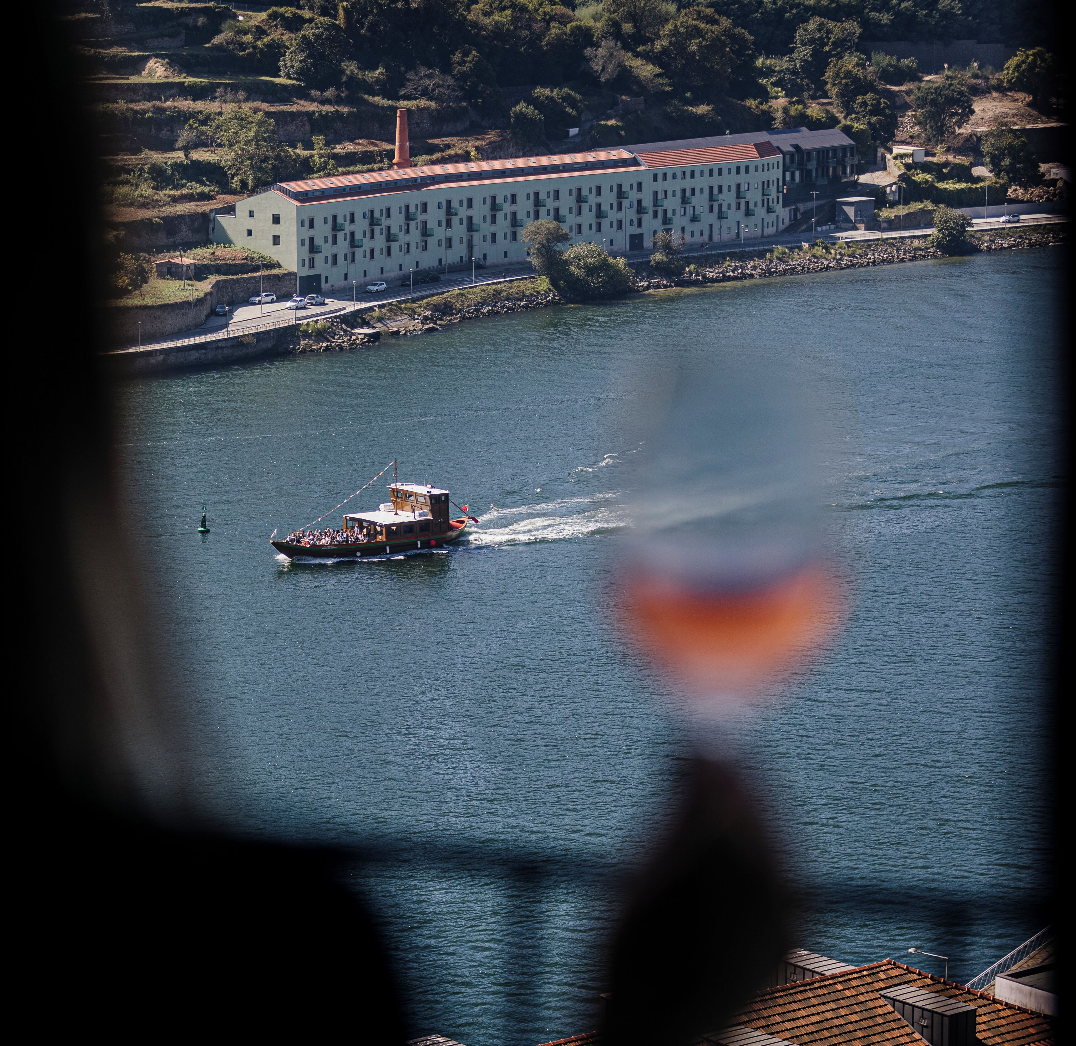 Un barco en un río con un edificio al fondo.