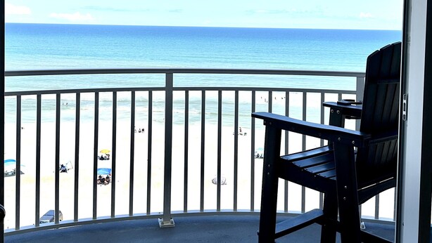 Ein Balkon mit Blick auf Strand und Meer.