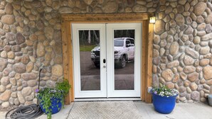 A stone building with a wooden door and two potted plants.