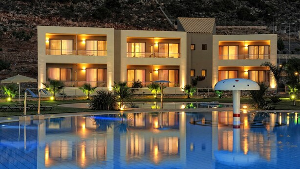 Ein modernes Hotel mit mehreren Etagen, einem Schwimmbad und einem angelegten Garten.
