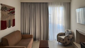 Ein Wohnzimmer mit Sofa, Sessel, Deckenventilator und Kamin.