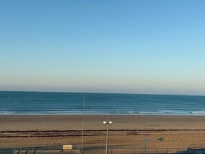 A beach with a clear sky, a sign indicating a post office, and a street lamp. - Beautiful waterfront apartment (Saint-Jean-de-Monts)