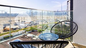 A balcony with a view of a cityscape, including a tall building. - Bloomfields Stu Riviera Skies (Dubai)