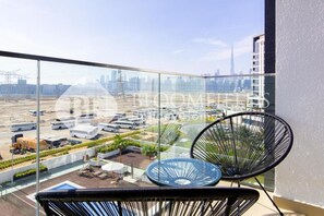 A balcony with a view of a cityscape, including a tall building. - Bloomfields Stu Riviera Skies (Dubai)