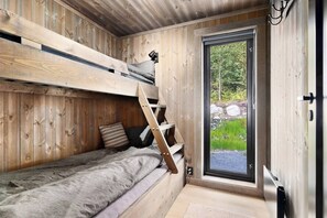 A compact room with a bunk bed, a small window, and a door leading outside. - New and Great Cabin at the Foot of Norefjell (Krodsherad)