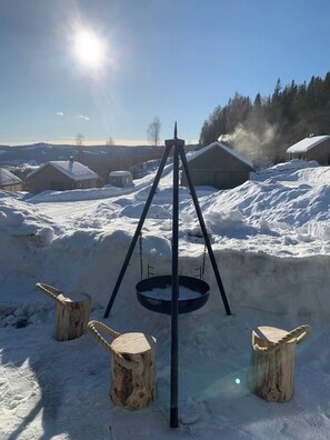 A snow-covered outdoor area with a swing set and wooden posts.